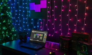 Twinkly Dots LED string lights set up on a wall behind a laptop.
