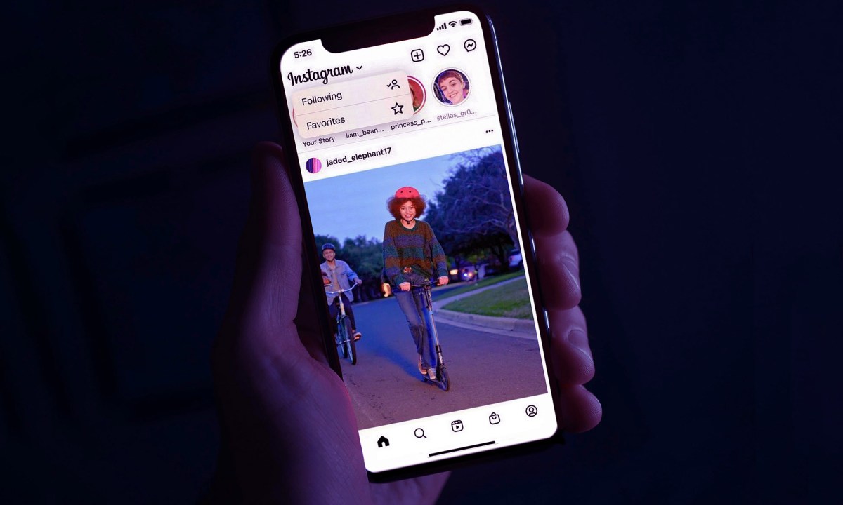 A person holds an iPhone in their hand while on the Instagram app.
