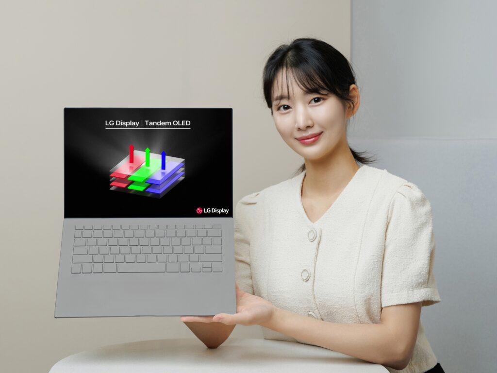 Una mujer sostiene una computadora portátil con el logotipo LG Tandem OLED.